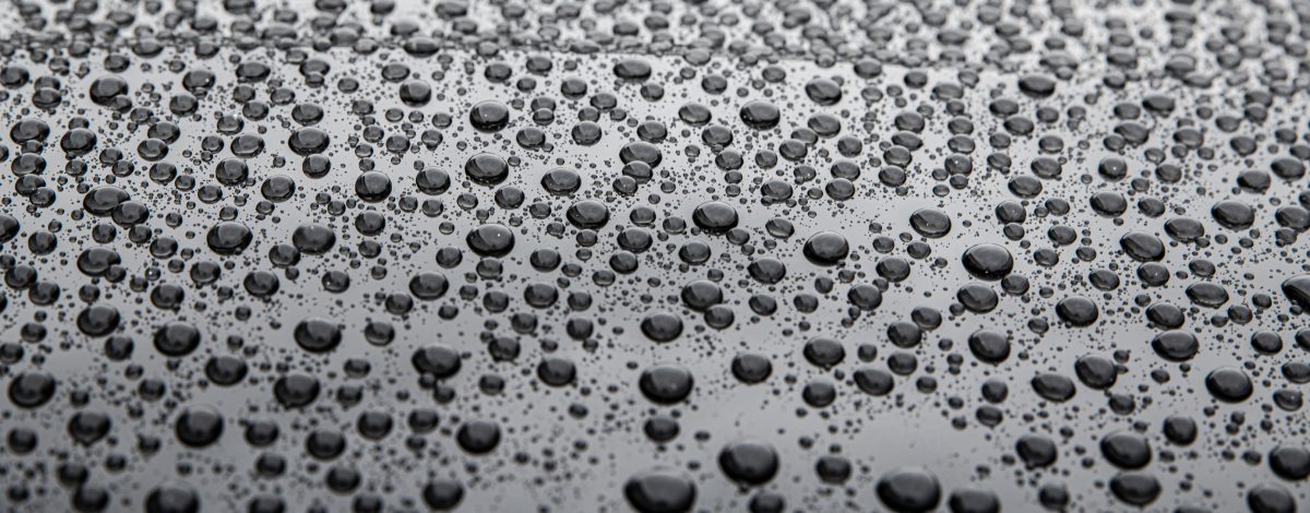 Water drops on car paint. Hydrophobic water effect on car body due to ceramic coating