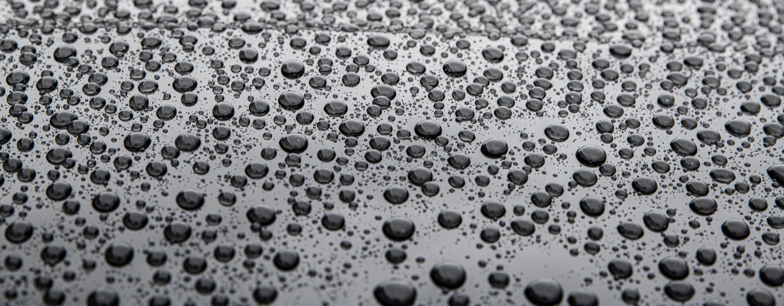 Water drops on car paint. Hydrophobic water effect on car body due to ceramic coating