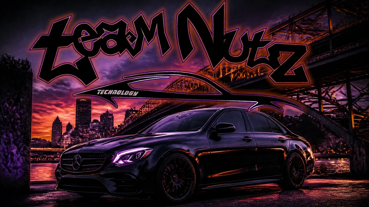 Black Mercedes sedan under purple neon graffiti reading 'Team Noiz' with a city skyline and bridge at sunset in the background.