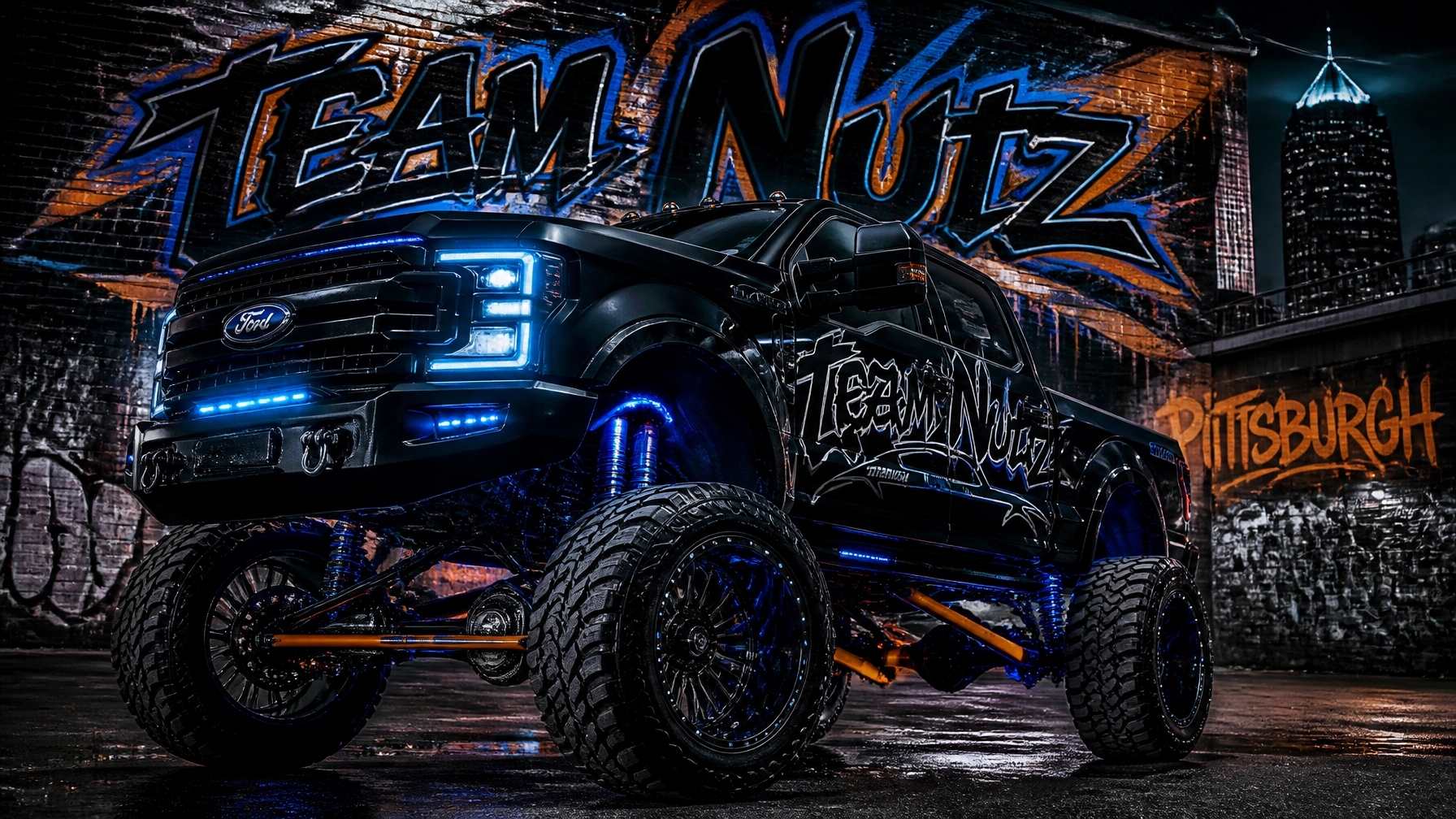 Monster black Ford monster truck with glowing blue lights and oversized tires in front of a graffiti wall that reads 'Team Nutz' and 'Pittsburgh' at night.