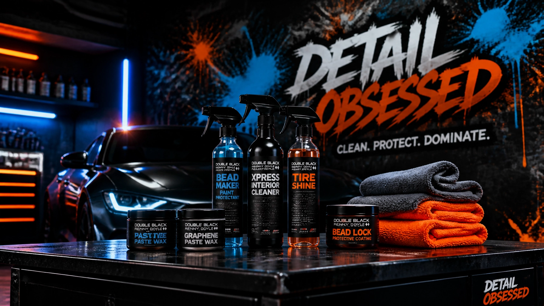 Automotive detailing products on a worktable with a car in the background and a neon-lit workshop wall saying 'Detail Obsess ed' and stacked towels nearby.